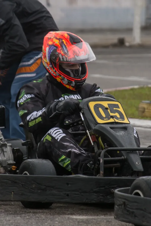 Piloto de kart com capacete laranja