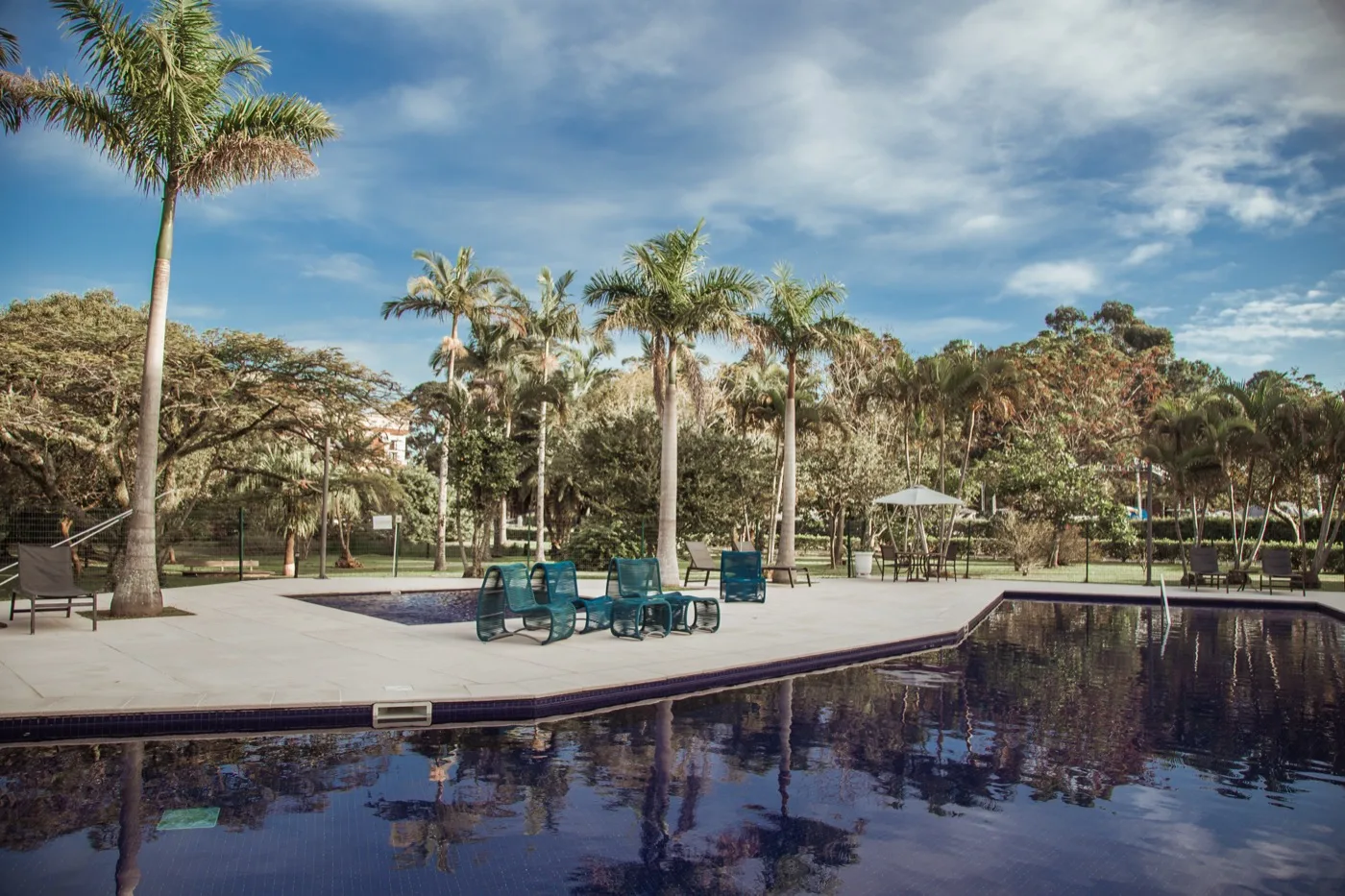 Piscina do resort com deck e palmeiras