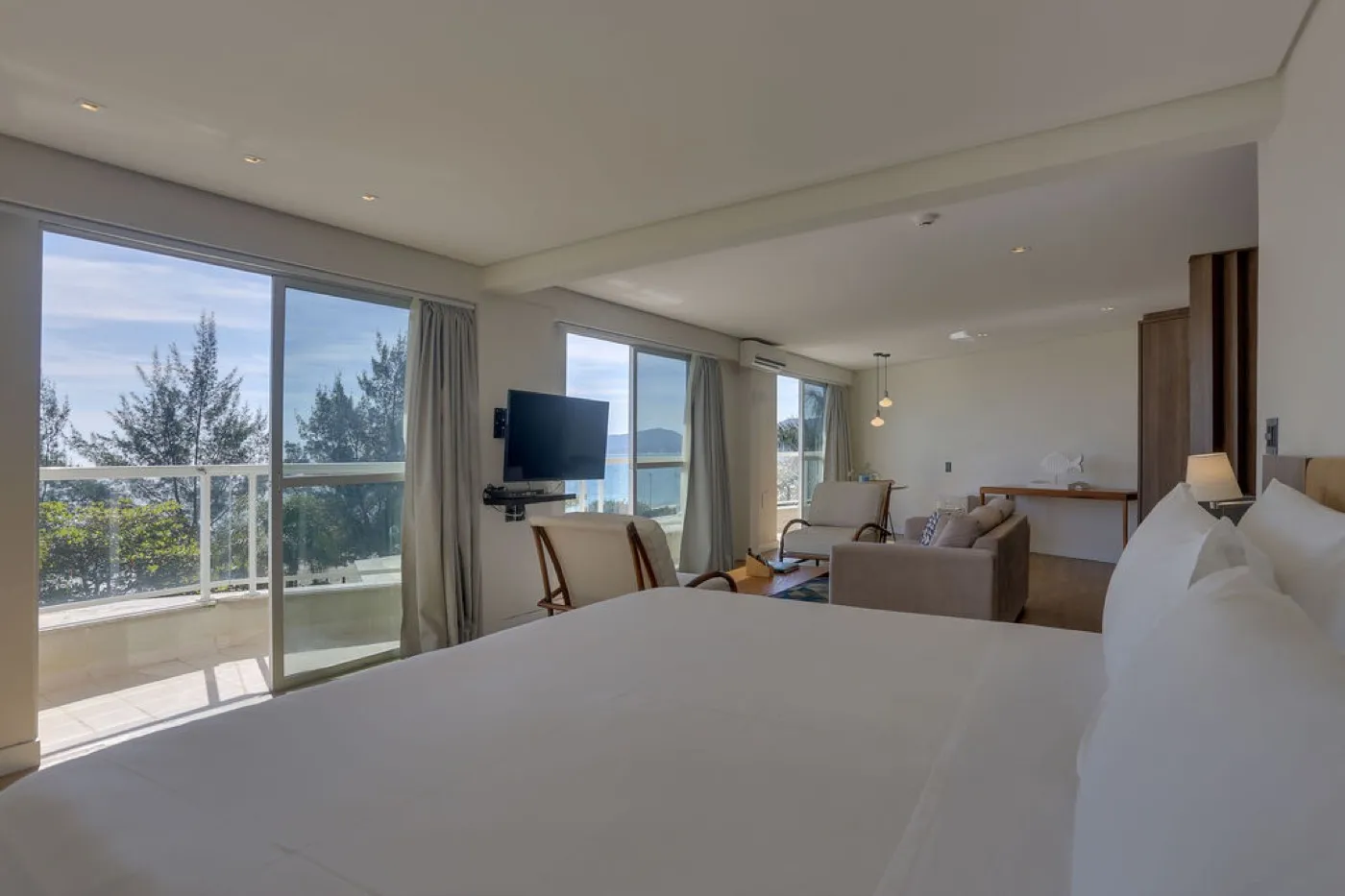 Suíte com cama king e varanda com vista para o mar
