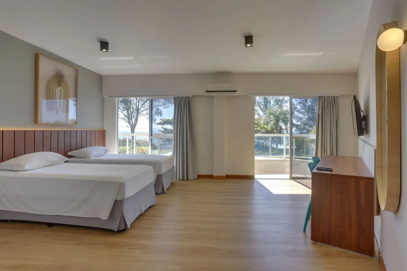 Quarto da suíte com duas camas e sacada